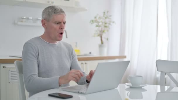 Старша людина з ноутбуком, який відчуває біль у себе вдома — стокове відео