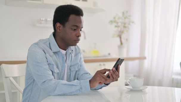 African Man świętuje sukces w Smart Phone — Wideo stockowe