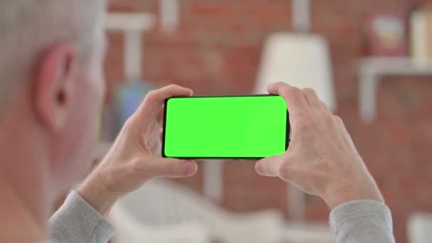 Starszy starzec patrząc na smartfon z ekranem Chroma — Wideo stockowe