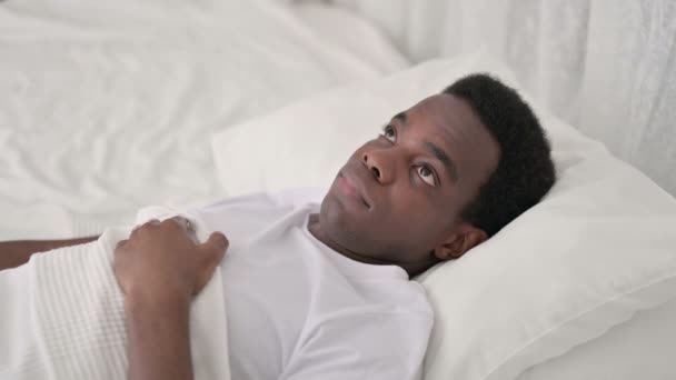 Беспокойный африканский мужчина просыпается в постели — стоковое видео