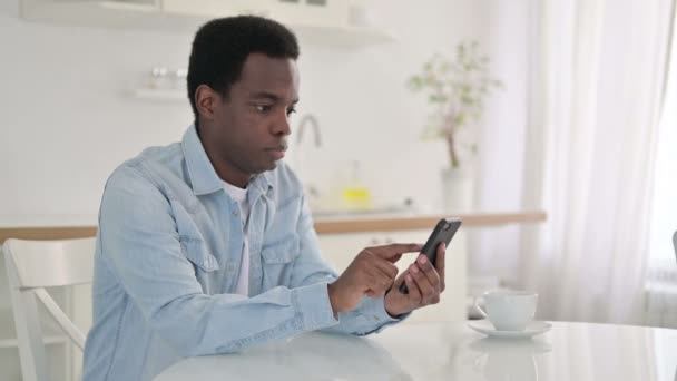African Man za pomocą smartfona w domu — Wideo stockowe