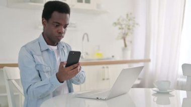 Evde Akıllı Telefon ve Laptop kullanan Afrikalı Adam 