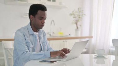 Dizüstü bilgisayarlı Afrikalı Kamerayı işaret ediyor 