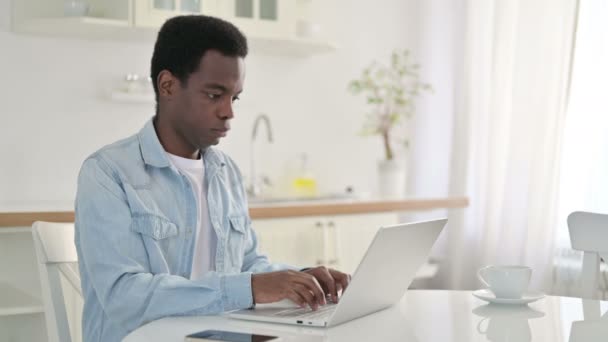 Homem Africano excitado comemorando o sucesso no laptop em casa — Vídeo de Stock