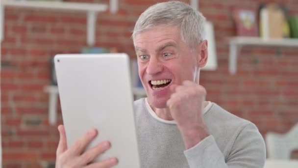 Älterer Mann feiert Erfolg mit Tablet — Stockvideo