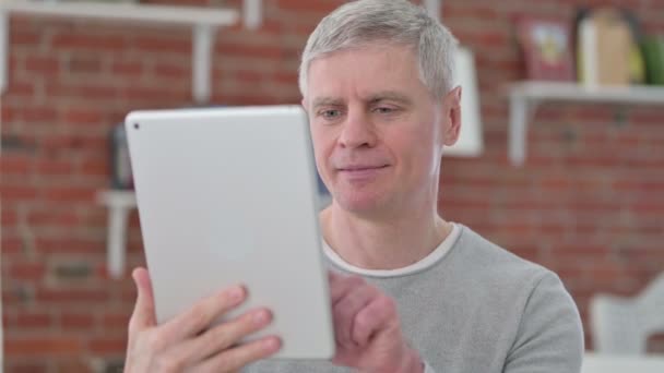 Poważny starszy człowiek za pomocą tabletu — Wideo stockowe