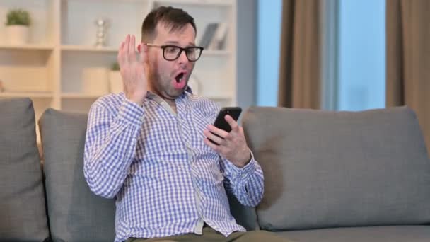 Pérdida, Hombre joven que tiene un fallo en el teléfono inteligente en casa — Vídeos de Stock