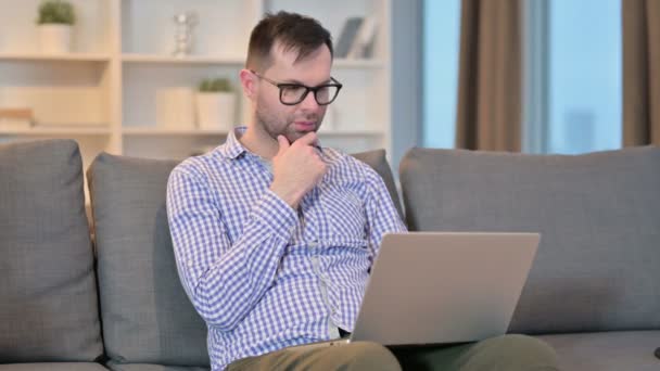 Trabalhador homem pensando e trabalhando no laptop em casa — Vídeo de Stock