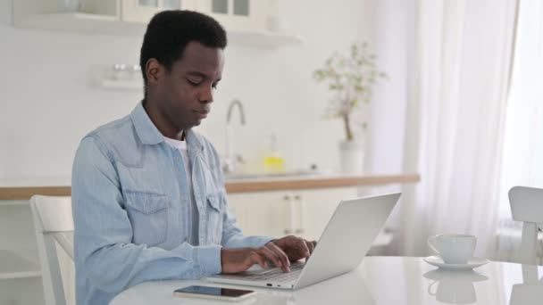 Uomo africano con computer portatile con dolore al polso a casa — Video Stock