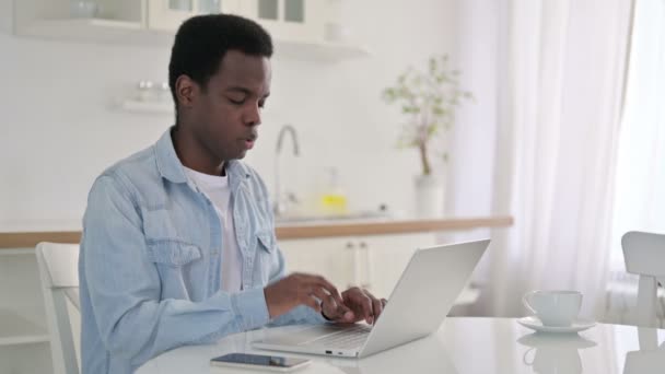 Cansado Africano Homem com Laptop com dor de cabeça em casa — Vídeo de Stock