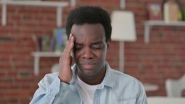 Yorgun Afrikalı adam baş ağrısı çekiyor.