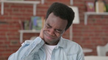 Yorgun Afrikalı adamın boynu ağrıyor.