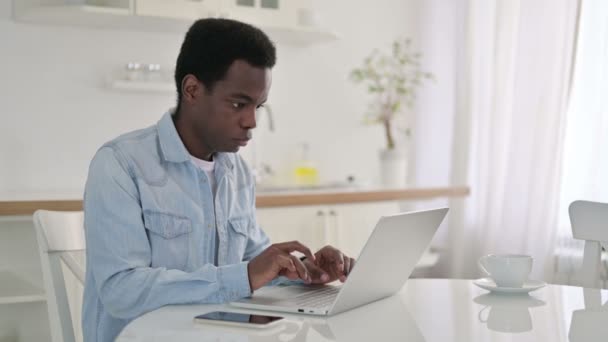 Hombre africano haciendo videollamada en el ordenador portátil en casa — Vídeo de stock