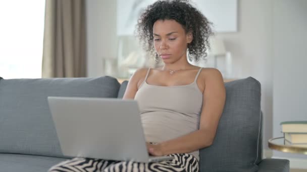 Χαμογελώντας African Woman Coming and Starting Laptop εργασίας στον καναπέ — Αρχείο Βίντεο