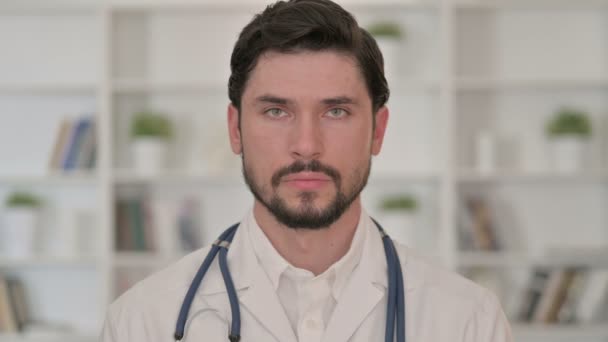 Ernsthafter junger Arzt blickt in die Kamera — Stockvideo