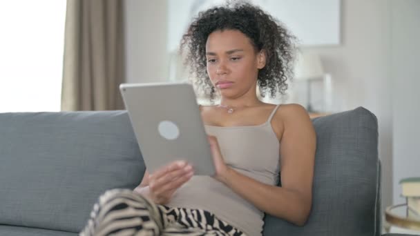 Femme africaine professionnelle sérieuse utilisant la tablette à la maison — Video