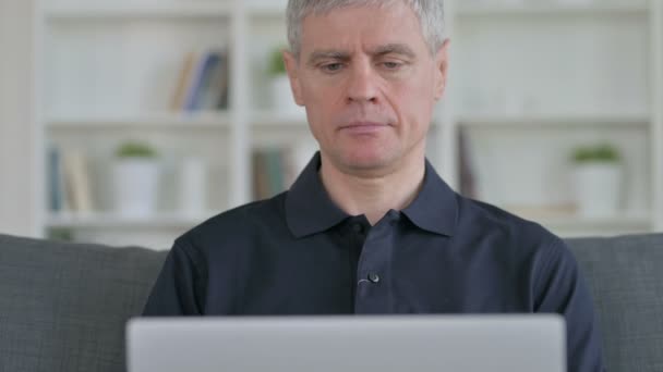Empresario de mediana edad que trabaja en el ordenador portátil en casa — Vídeo de stock