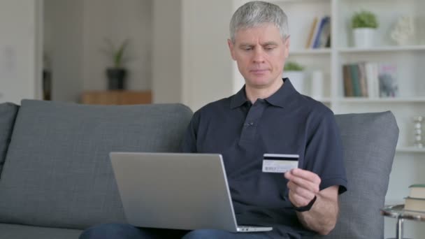 Бізнесмен середнього віку робить успішні онлайн платежі на ноутбуці — стокове відео