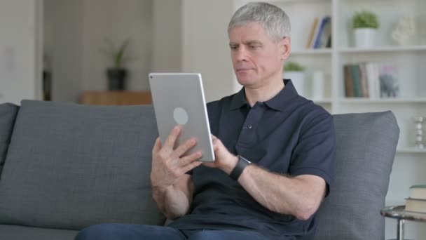 Iloinen keskiaikainen liikemies käyttäen Tablet on Sohva — kuvapankkivideo