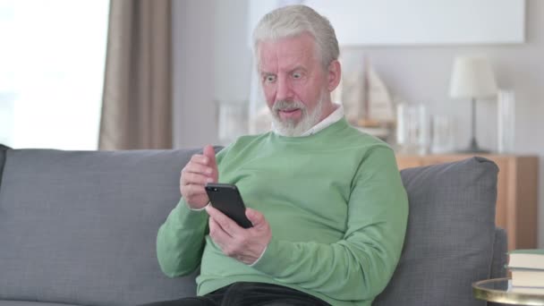 Senior Gamla Affärsman Fira Framgång på Smartphone hemma — Stockvideo