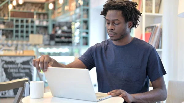 Afrikansk man öppnar laptop i Café — Stockfoto