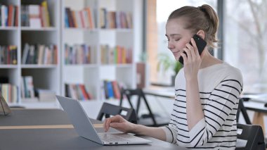 Kütüphanede Akıllı Telefonla Konuşan Genç Kadın