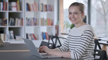 Kütüphanedeki Kameraya Gülümseyen Genç Kadın