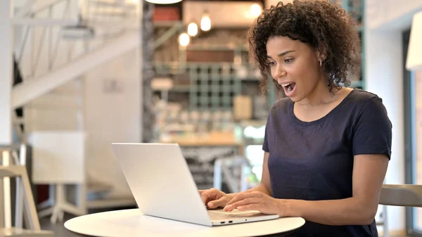 Preguntándose Mujer Africana joven feliz usando el ordenador portátil en Café —  Fotos de Stock
