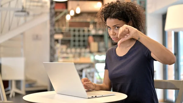 Jovem mulher africana com laptop mostrando polegares para baixo — Fotografia de Stock