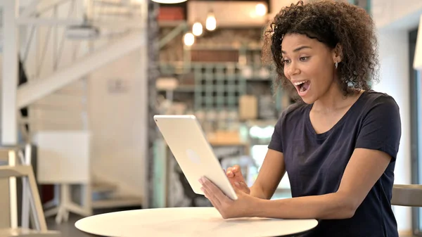 Jovem mulher africana animado por resultados em Tablet no Café — Fotografia de Stock