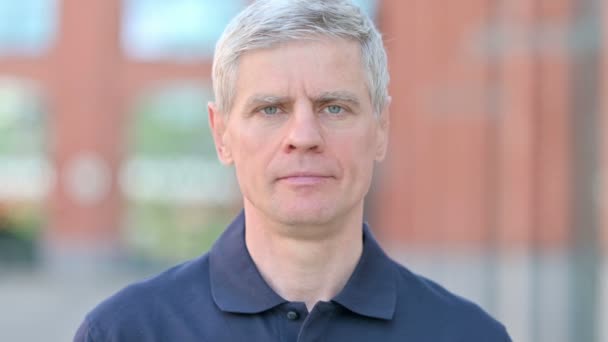 Retrato al aire libre del alegre hombre de mediana edad sonriendo ante la cámara — Vídeos de Stock