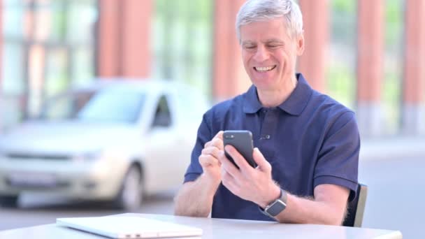 Uomo d'affari di successo all'aperto di mezza età che celebra su Smartphone — Video Stock