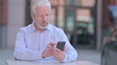 Smartphone kullanan Odaklanmış Eski İş Adamı