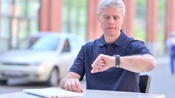 На улице в ожидании средневекового бизнесмена, чеканящего время на смартфоне — стоковое видео