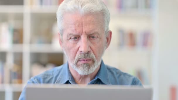 Porträtt av fokuserad äldre affärsman som arbetar på laptop — Stockvideo