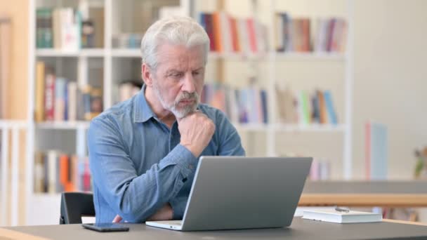 Old Man thinking and working on Laptop in Library — 비디오