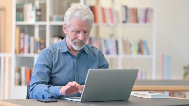 도서관에서 노트북으로 성공을 축하하는 노인 — 비디오