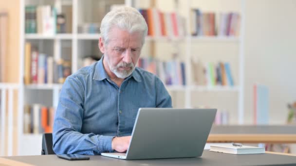 Trauriger älterer Mann scheitert mit Laptop in Bibliothek — Stockvideo