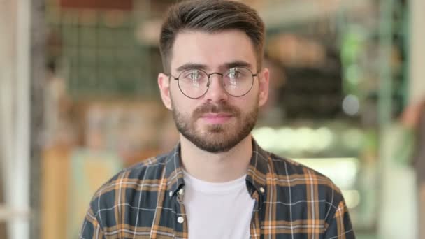A boldog fiatalember portréja, amint a szív jelét mutatja kézzel — Stock videók