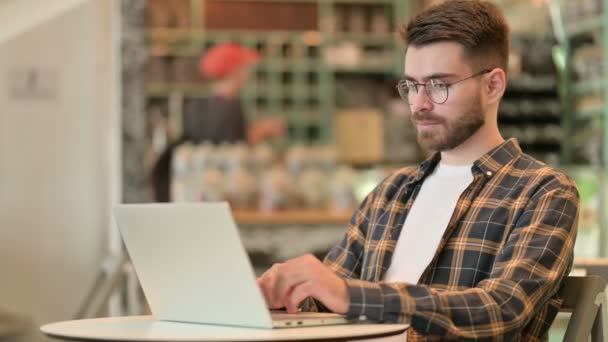 Professionele jongeman met behulp van laptop in Cafe — Stockvideo
