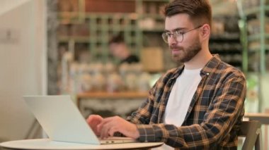 Neşeli Genç Adam Kafede Parmaklarıyla İşaret Ediyor 