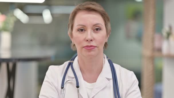 Middelbare leeftijd vrouwelijke arts tonen Bel me voor hulp Teken — Stockvideo