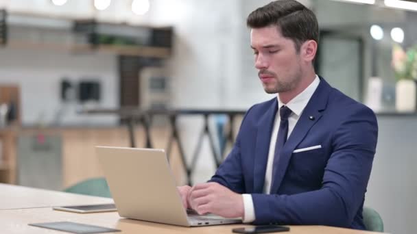 Hardwerkende zakenman met laptop met rugpijn in kantoor — Stockvideo