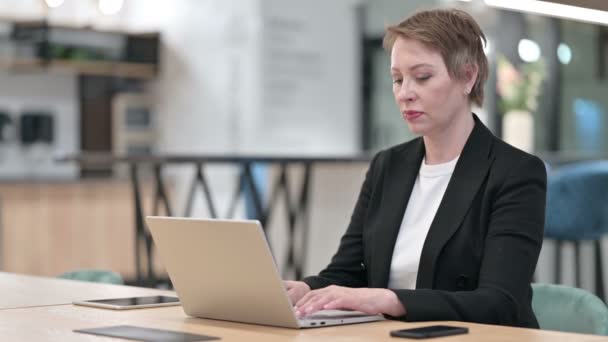 Vieille femme d'affaires avec ordinateur portable pointant vers la caméra — Video