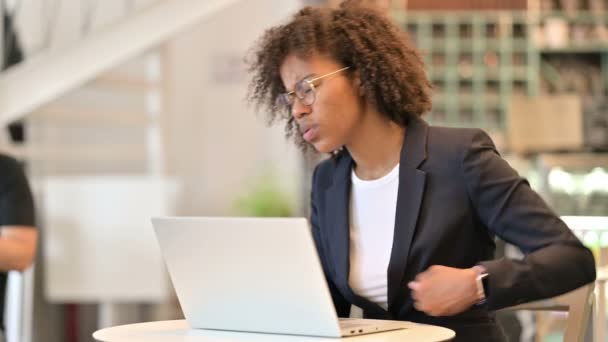 Donna d'affari africana stanca con computer portatile che ha mal di schiena al Cafe — Video Stock