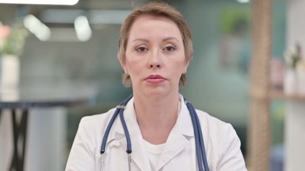 Серйозна жінка середнього віку лікар дивлячись на камеру — стокове відео