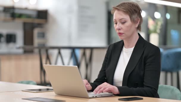 Fokussierte alte Geschäftsfrau arbeitet im Büro am Laptop — Stockvideo