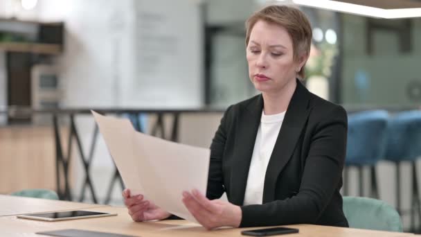 Vieja empresaria leyendo documentos en la oficina — Vídeo de stock