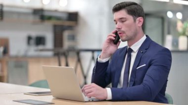 Bilgisayarlı İşadamı Ofiste Akıllı Telefonla Konuşuyor 