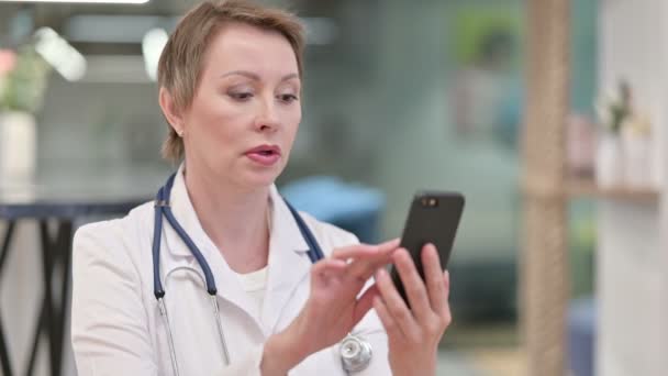 Médico femenino de mediana edad enfocado usando Smartphone — Vídeos de Stock